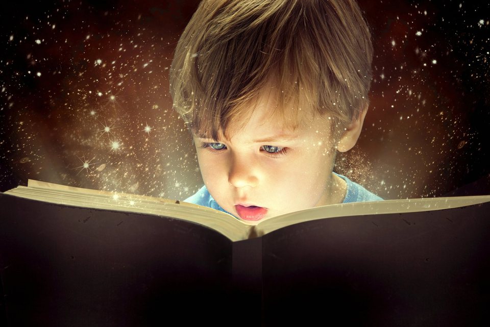 A child reading a glowing magic book and discovering the wonder of learning magic