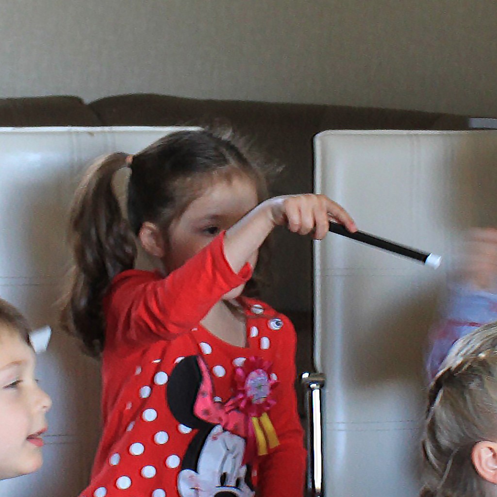 A child holding a magic wand during a birthday activity